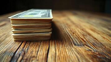 A stack of money sitting on top of a wooden table photo