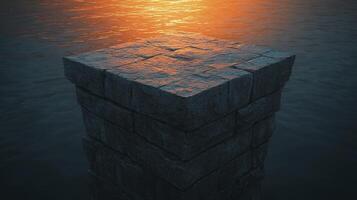 A stone pillar in the middle of the ocean with the sun setting photo