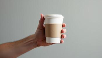 Hand holding a paper cup of coffee photo