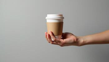 A person holding a paper cup of coffee photo