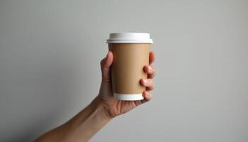 A person holding a paper cup with a lid photo