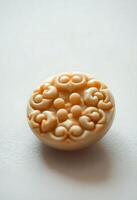 close up of a button on a white surface photo