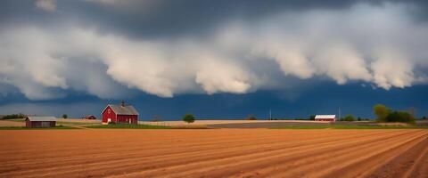 farm field with a red barn under a cloudy sky photo
