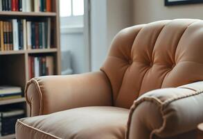 brown chair sitting in front of a book shelf photo