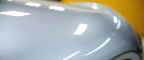 close up of a car's hood with a yellow wall in the background photo