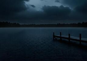 A dock in the middle of a lake under a dark sky photo