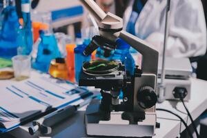 A microscope is on a table with a person looking at it photo