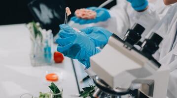 Scientists in lab coats and gloves working on a microscope photo