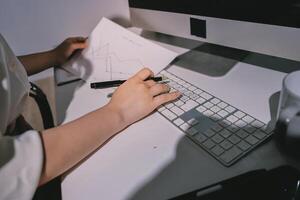 A person is working on a computer with a piece of paper photo
