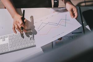 A person is working on a graph paper with a keyboard and mouse photo