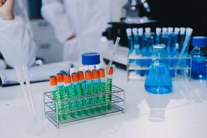 A laboratory with several test tubes and a man in a lab coat photo