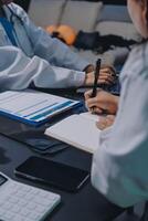 Two doctors writing on a notebook while sitting at a table photo