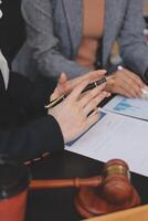 Two business people sitting at a desk with papers and a gavel photo