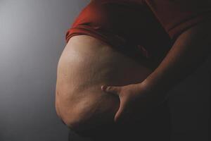 A man with a large belly on a gray background photo