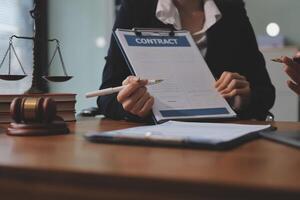 Two business people sitting at a desk with a contract photo