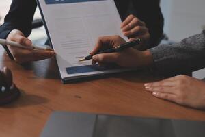 Two people are signing a document on a table photo