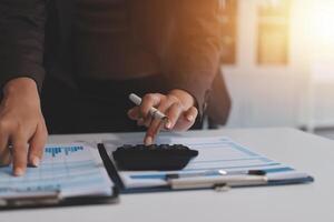 A businesswoman is using a calculator to make a financial plan photo