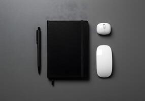 Overhead view of office supplies notebook pen and two computer mice on dark surface photo