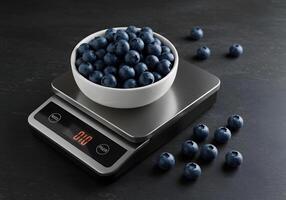 Fresh blueberries in a white bowl on a digital scale against dark background photo