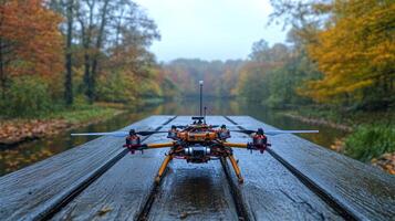 A small drone sitting on a wooden bridge in the fall photo