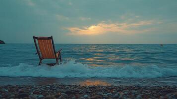 A chair sitting on the beach at sunset photo