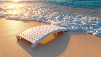A wooden bench on the beach at sunset photo