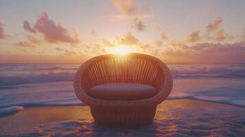 A wicker chair sits on the beach at sunset photo