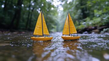 Two yellow sailboats floating in a stream photo