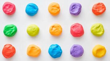 Colorful play dough balls arranged in a circle on a white surface photo