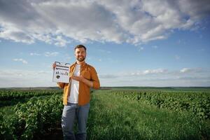 Graphs and business ,analytics on document, notepad. Handsome man is on the agricultural field at daytime photo