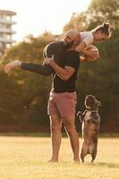 Girlfriend is with ,,soccer ball. Man and woman are with dog on the field photo