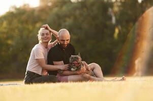 Man, and woman are with dog on the field. photo