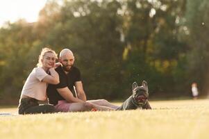 Man, and woman ,are with dog on the field photo