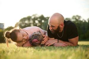 Front ,view, taking ,care of animal. Man and woman are with dog on the field photo