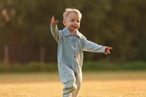 Having fun, running., Little boy is on the summer field photo
