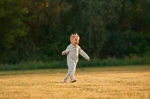 Having fun,,, running. Little boy is on the summer field photo