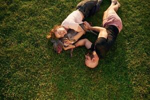 Top view,, lying on the grass. Man and woman are with dog on the field photo
