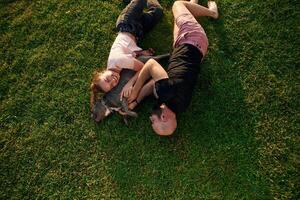 Top, view, lying on the grass. Man and woman are with dog on the field photo
