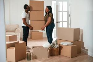 Bunch of boxes. African American ,couple are moving into new house photo