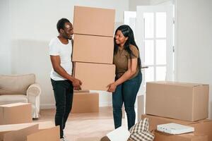 Bunch ,of boxes. African American couple, are moving into new house photo