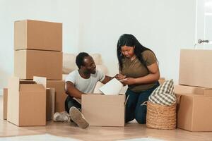 Making notes ,into ,notepad. African American couple are moving into new house photo