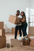 Holding boxes... African American couple are moving into new house photo