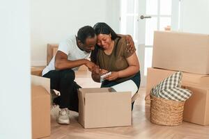 Making notes, into notepad. African American couple are moving into new house photo