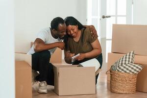 Making, notes into notepad. African American couple are moving into new house photo