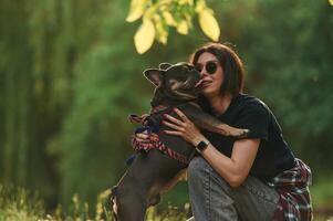 Playing on the grass. Young pretty woman is with her dog in the park. photo