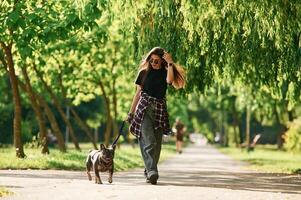 Hawing a walk., Young pretty woman is with her dog in the park photo