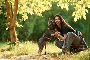 Sitting on the grass, ,,,embracing an ,animal. Young pretty woman is with her dog in the park photo