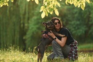 Playing on, the grass. Young pretty woman is with her dog in the park photo