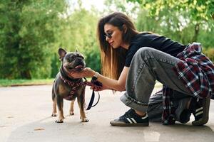 Weekend, activities. Young pretty woman is with her dog in the park photo