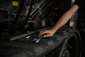 Close up view,,. Mechanic's hand fixing machinery with wrench in workshop photo